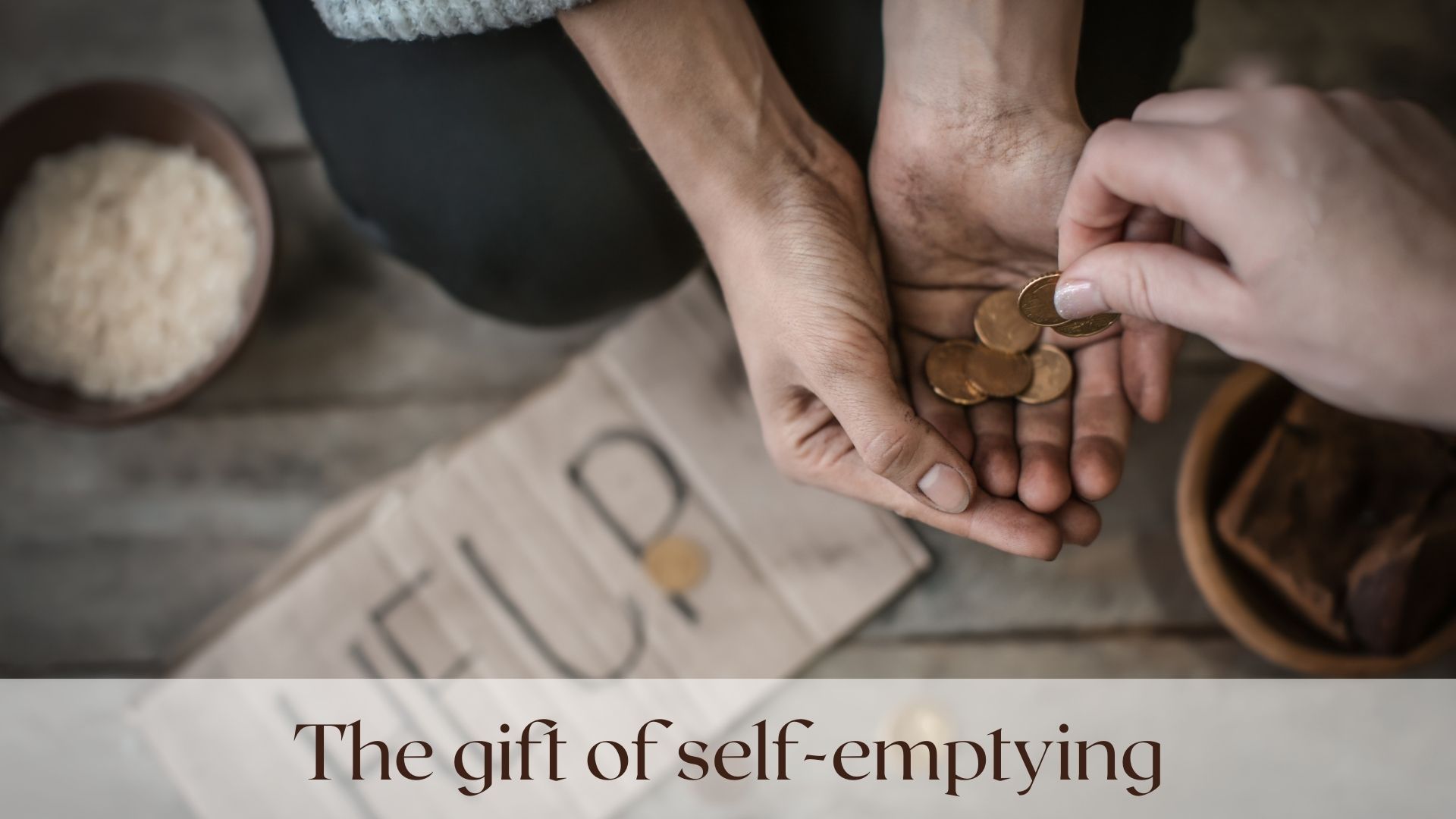 A woman kneeling on the street receives coins into her outstretched hand