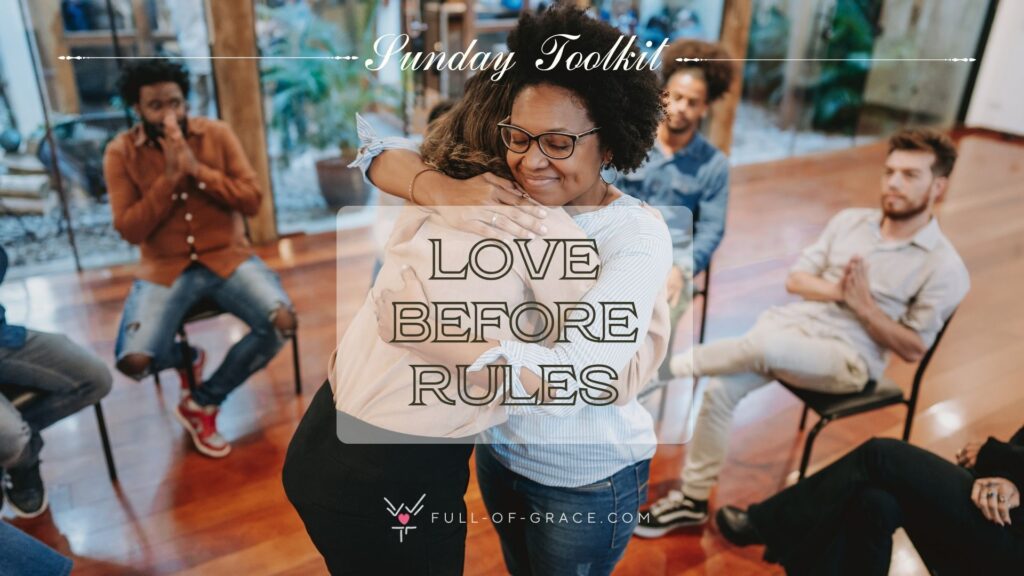 A community sitting together in a circle, appreciating two members in the middle sharing a heartfelt hug - text overlay - Love Before Rules - Sunday Toolkit graphic - full-of-grace.com